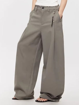 Men's grey high-waisted wide leg sweatpants with button closure and decorative charm.