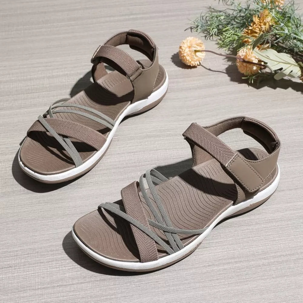 Khaki adjustable open-toe sandals with criss-cross straps and white soles.