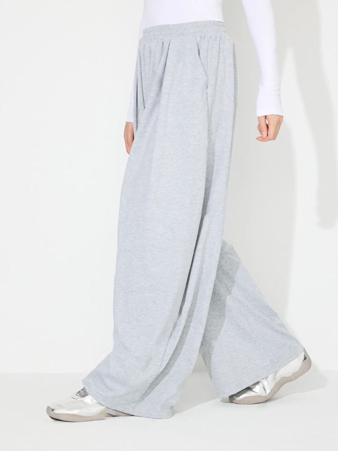 Light gray pleated drape palazzo trousers with a wide leg and elastic waistband.