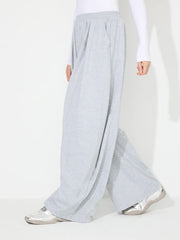 Light gray pleated drape palazzo trousers with a wide leg and elastic waistband.