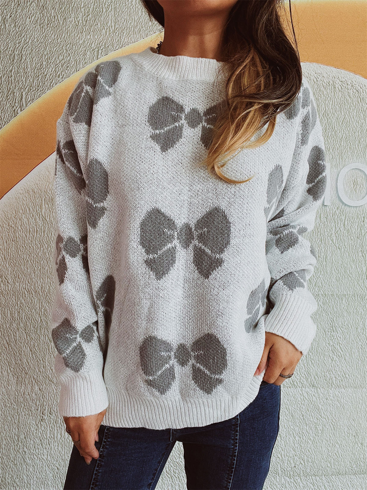 Gray bow print relaxed fit sweater with crew neck and long sleeves.