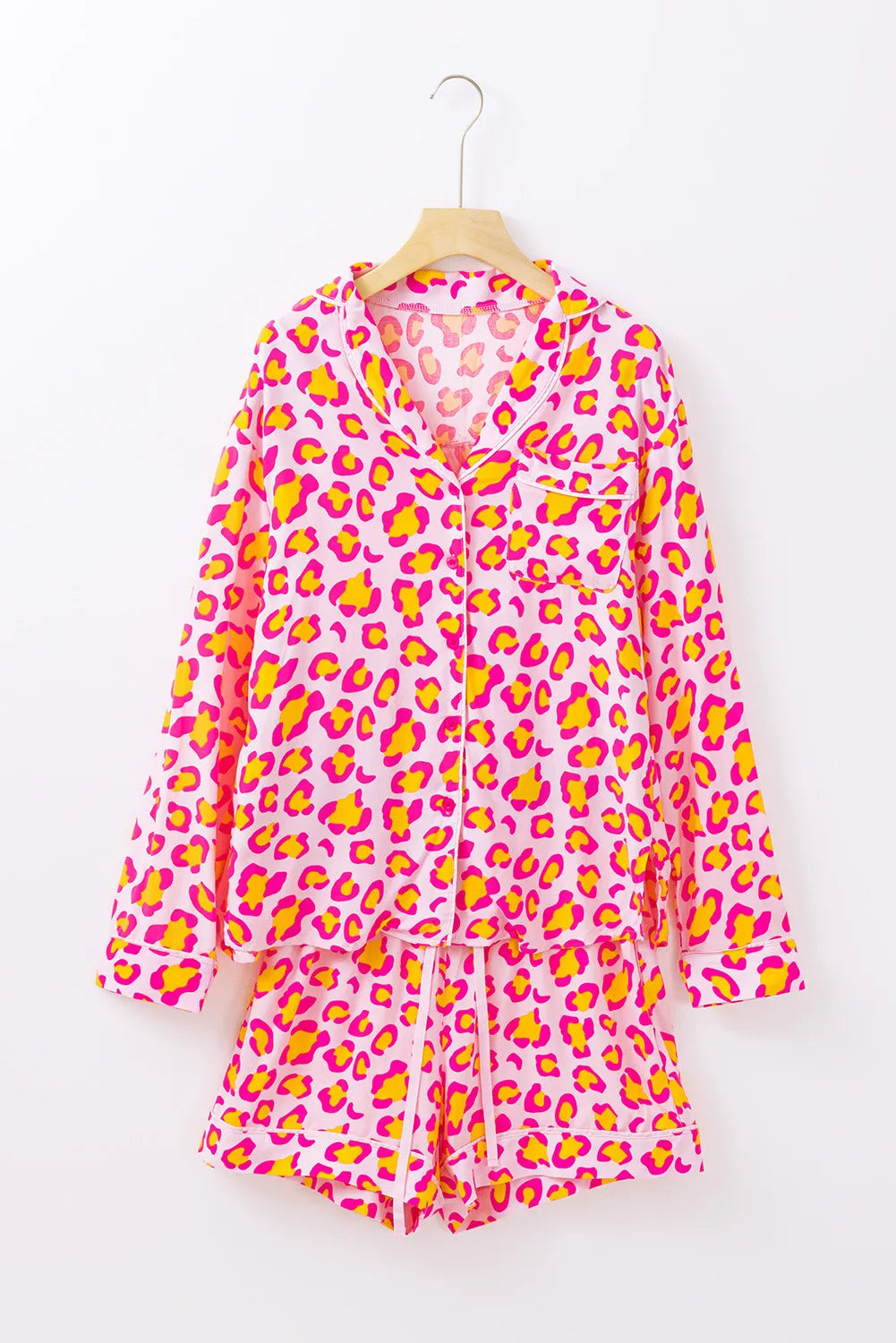 Pink leopard print satin pajama set with collared button-up top and drawstring shorts.