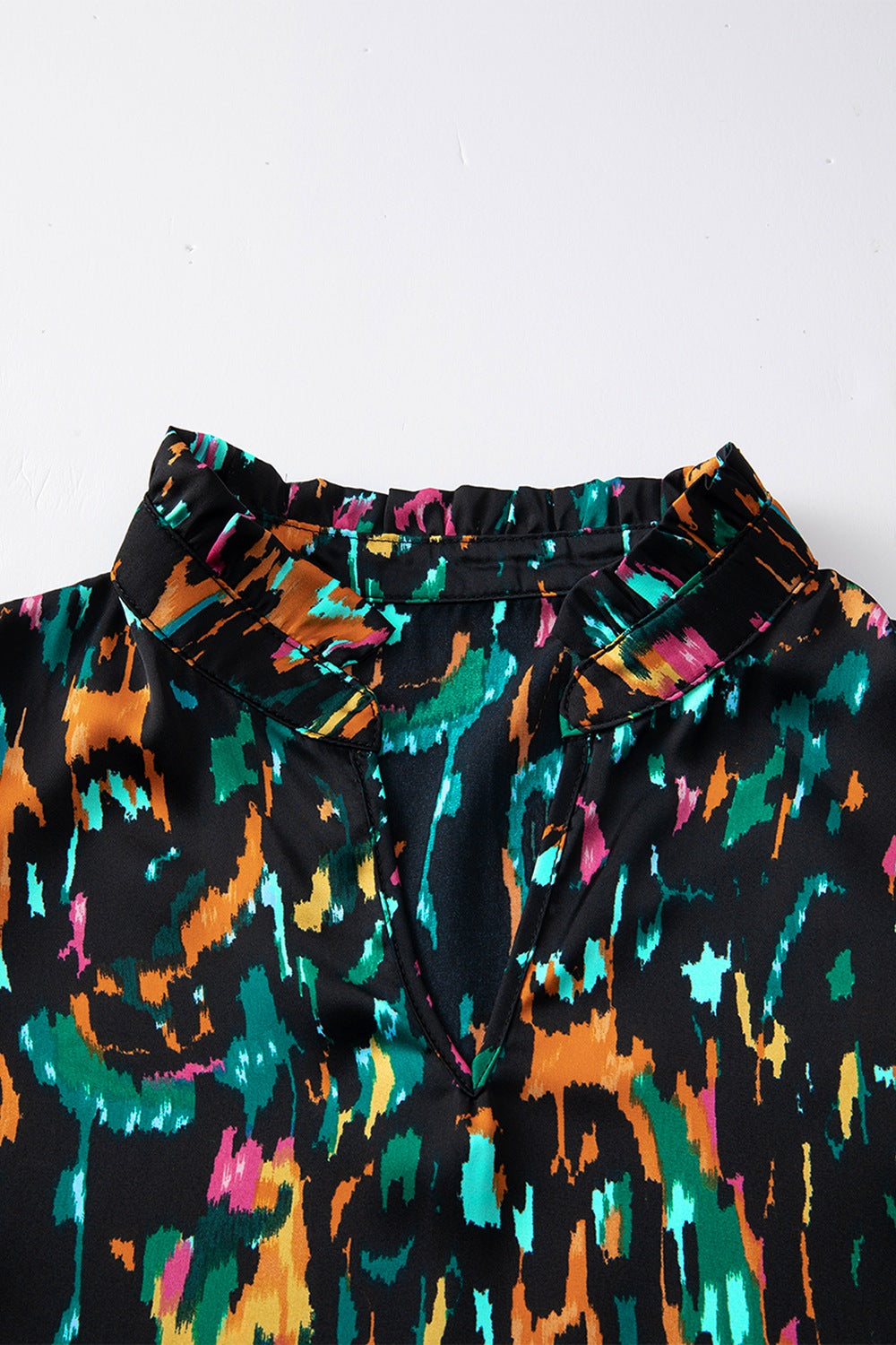 Black abstract print blouse with ruffled collar and V-neckline
