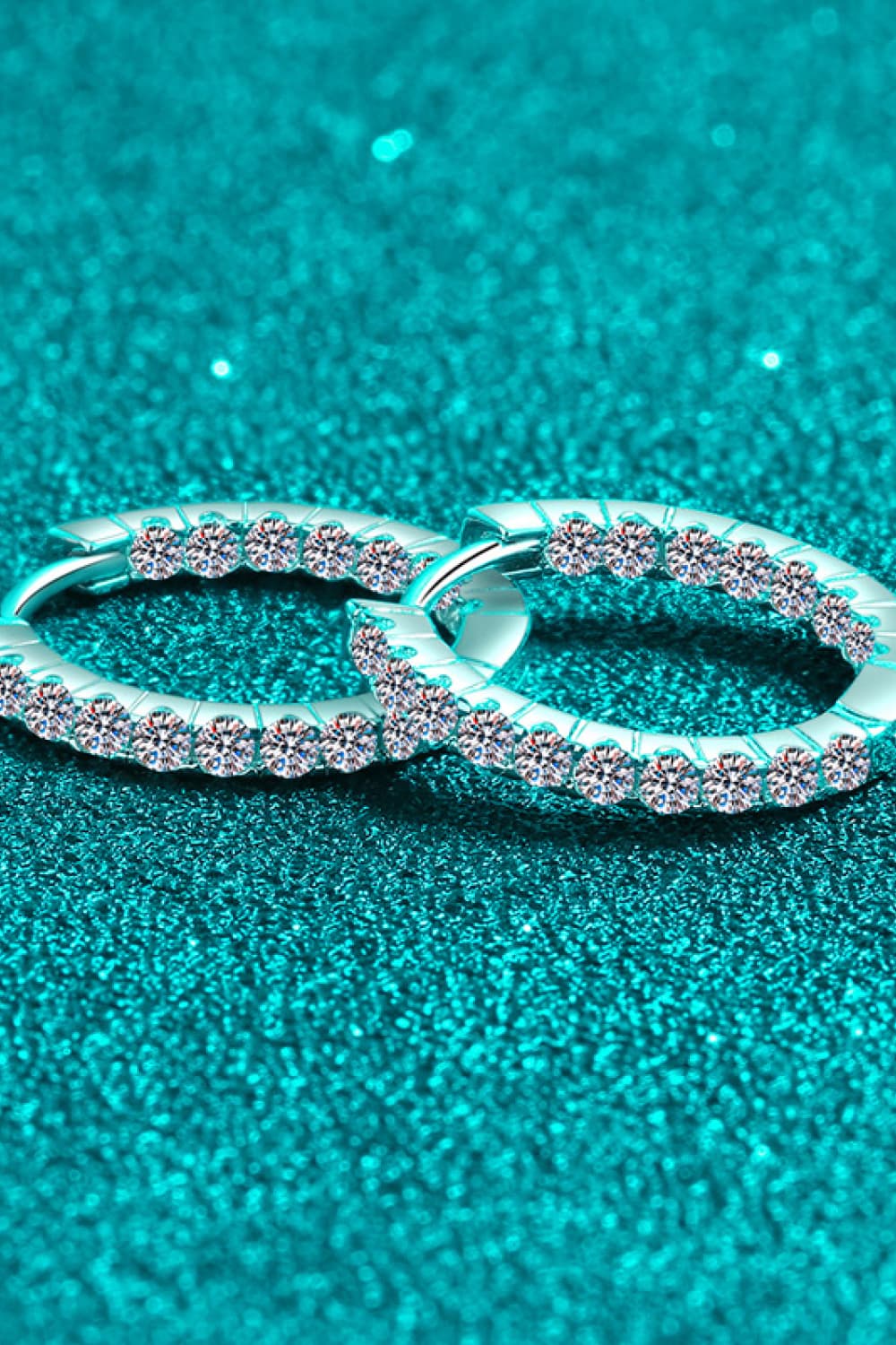 Silver pavé crystal huggie hoop earrings with sparkling stones.