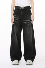 Faded black denim palazzo trousers with a wide leg and high waist, styled with a belt.