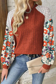Terracotta ribbed knit top with floral print sleeves and lace shoulder detail.