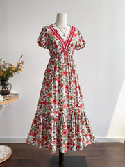 Vibrant floral V-neck midi dress with red trim and tiered skirt.