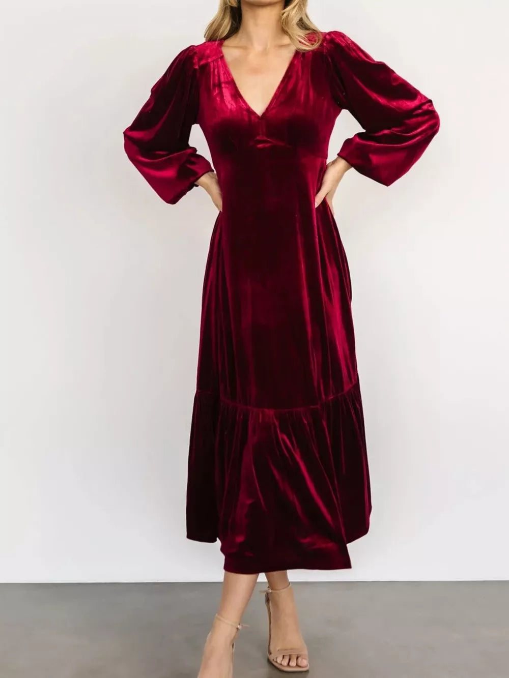 Burgundy velvet midi dress with V-neck, puff sleeves, and tiered skirt.