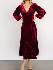 Burgundy velvet midi dress with V-neck, puff sleeves, and tiered skirt.