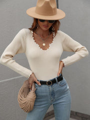 Cream ribbed knit top with scalloped neckline and cuffs, long sleeves.