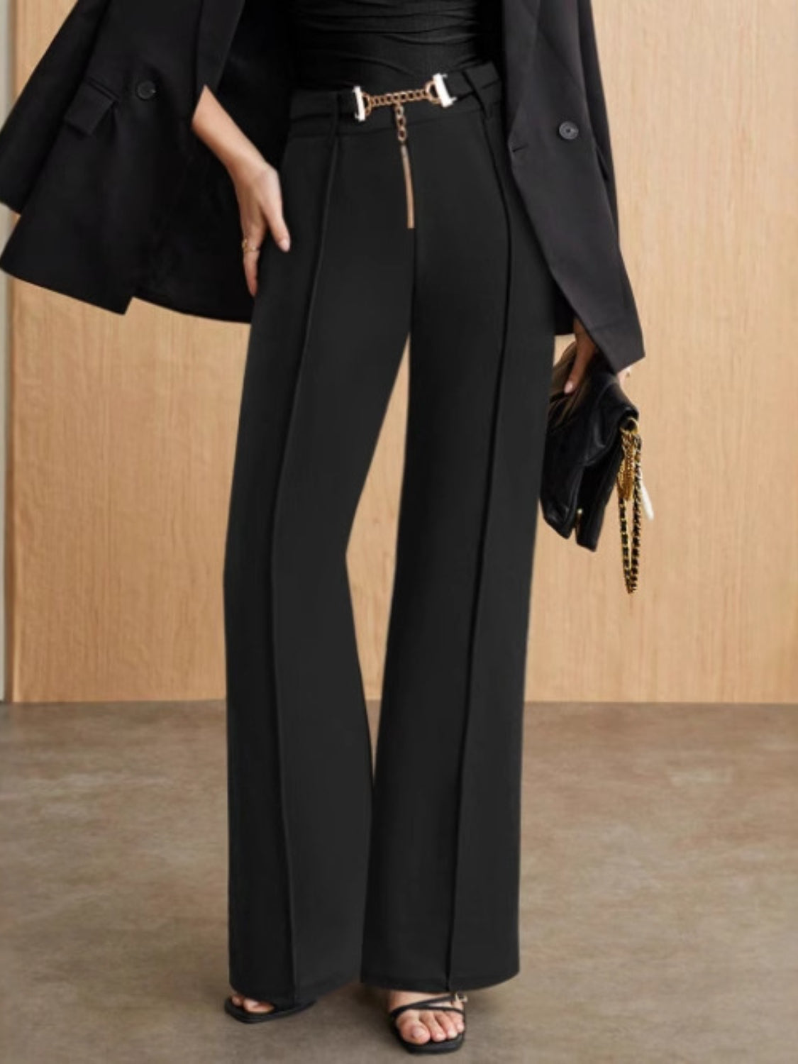 Black flared leg trousers with chain detail at the waist