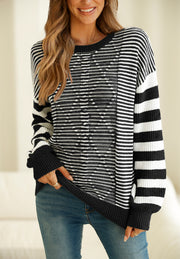 Black and white geometric stripe knit sweater with crew neck and long sleeves.