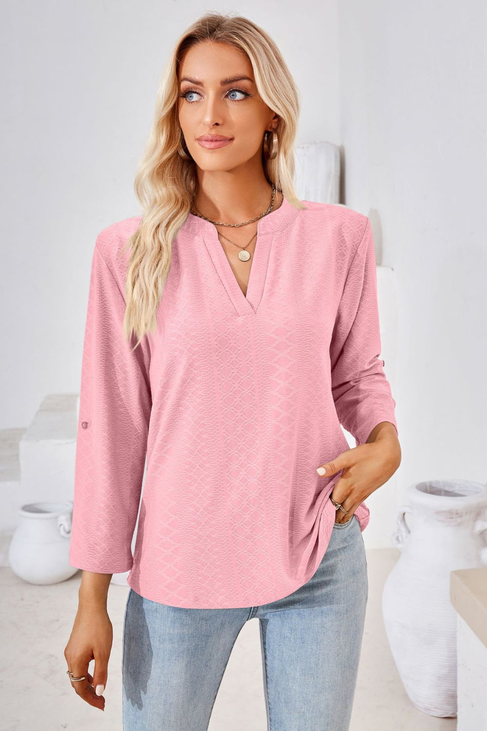 Pink textured henley blouse with V-neck and rolled sleeves