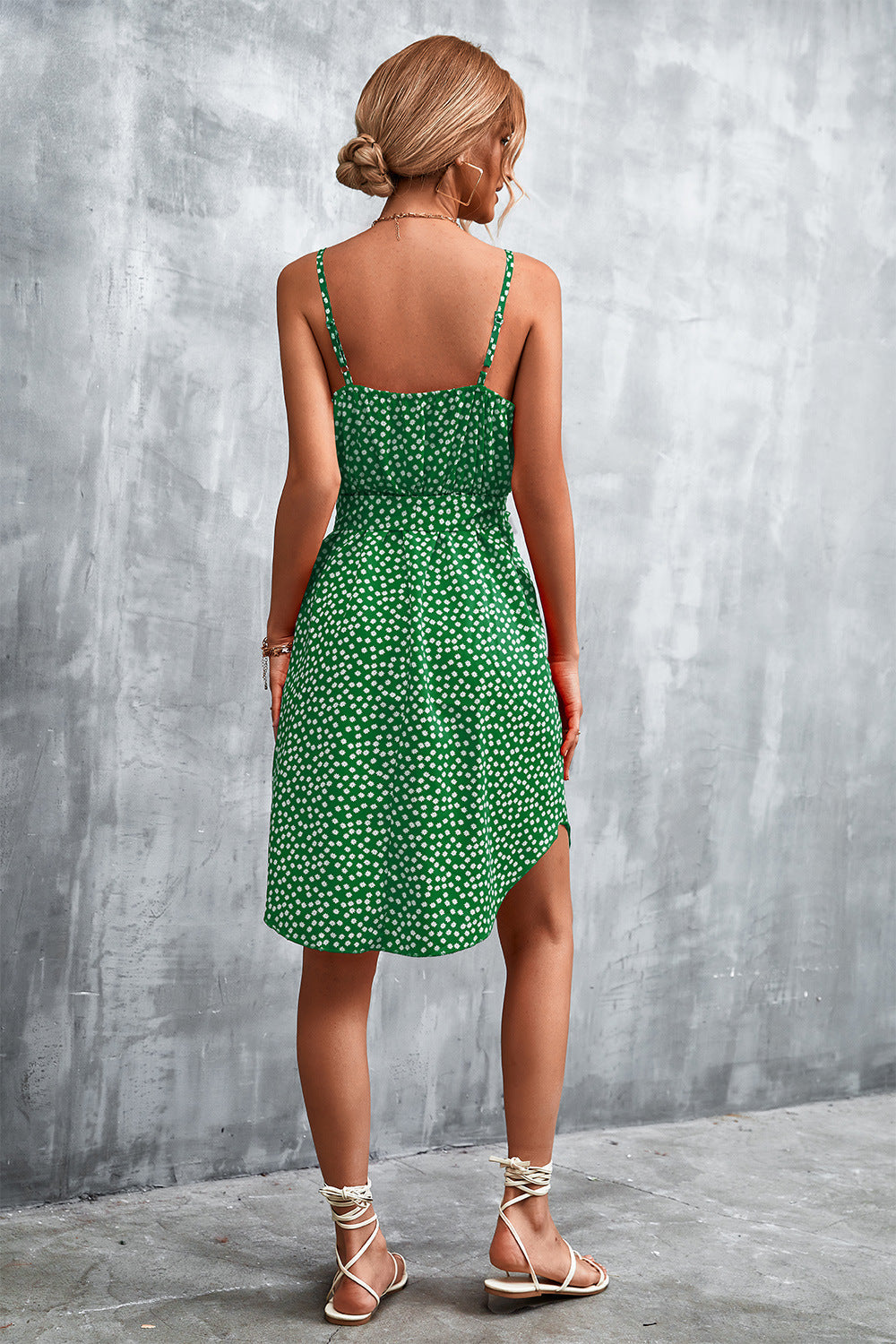 Green daisy print slip dress with tie waist and asymmetrical hem.