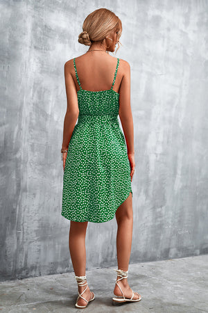 Green daisy print slip dress with tie waist and asymmetrical hem.