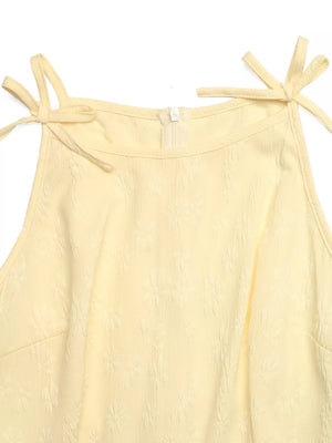 Yellow textured wide-leg jumpsuit with tie straps and a zipper closure.