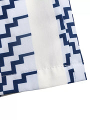 Geometric striped strapless wide-leg romper with navy blue and white pattern.