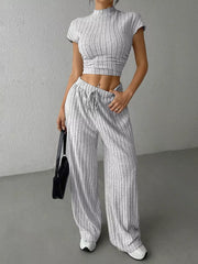 Grey ribbed knit set with mock neck crop top and drawstring wide leg pants.