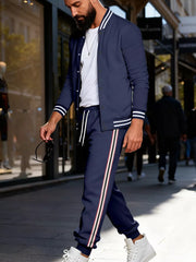 Navy track pants with white drawstring and red, white, black side stripes.