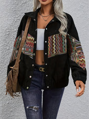 Black corduroy bomber jacket with colorful embroidered patchwork details on chest and sleeves.
