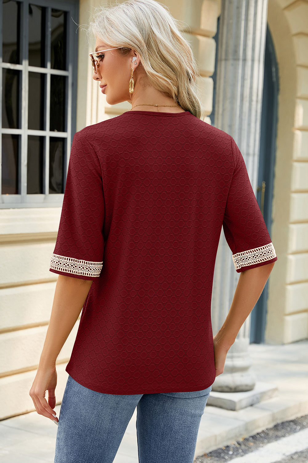 Burgundy textured V-neck blouse with lace trim on sleeves.
