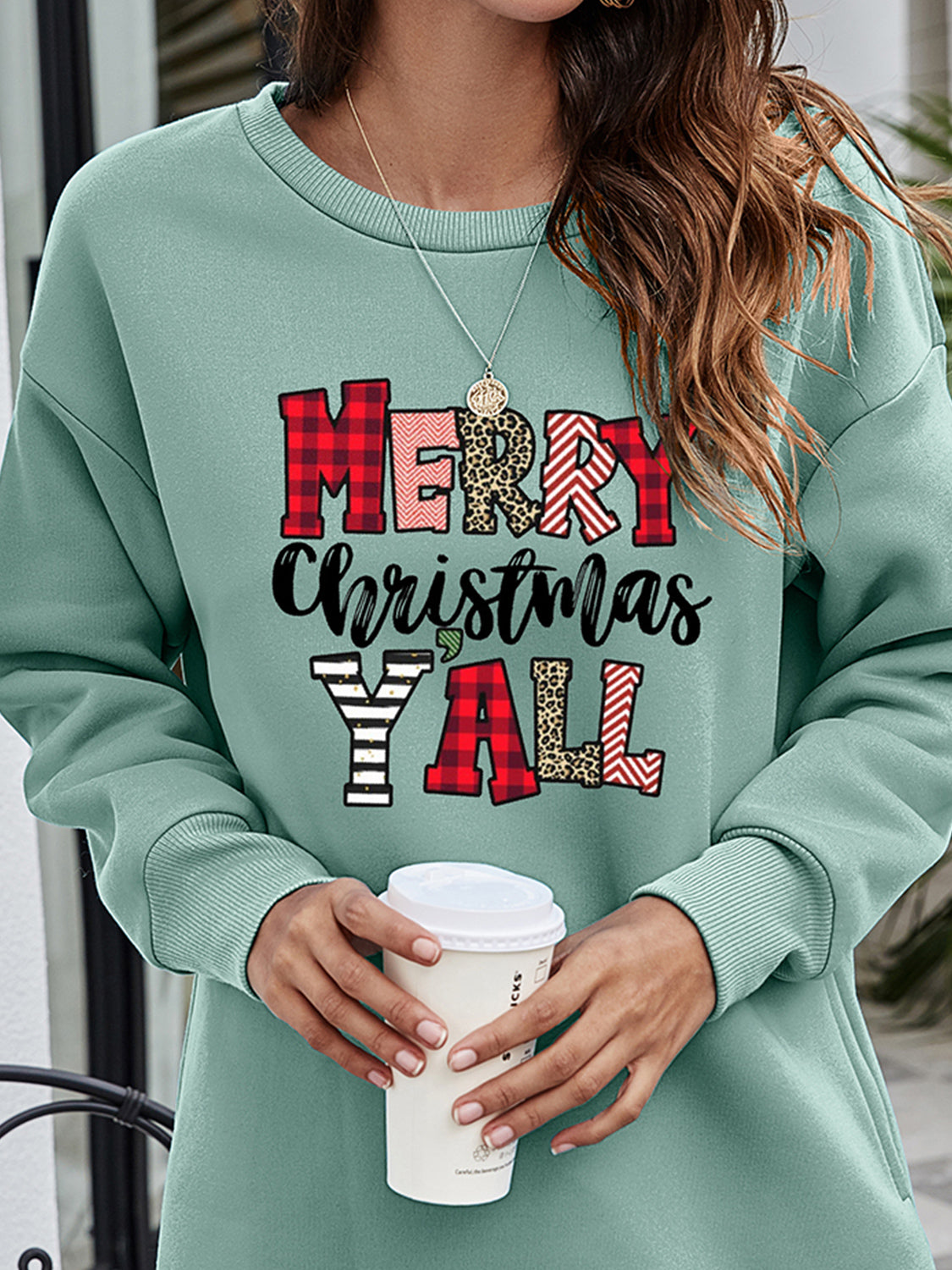 Sage oversized sweatshirt with "Merry Christmas Y'all" graphic in plaid, leopard, and chevron patterns.