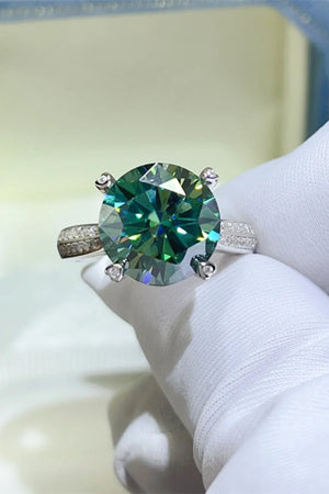 Dark green moissanite solitaire ring with a detailed silver band.