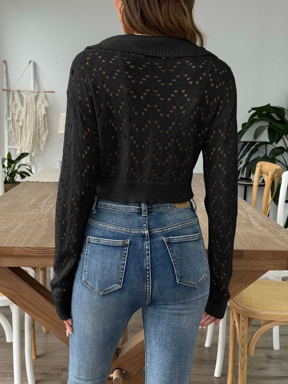 Black cropped pointelle knit polo top with a collared neckline and long sleeves.