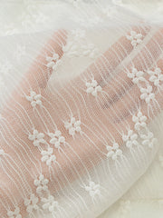 White lace mini dress fabric with floral embroidery and sheer texture