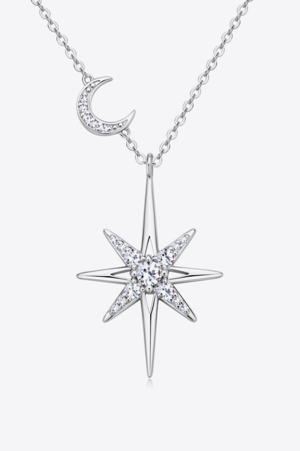 Silver celestial starburst pendant necklace with crescent moon charm, adorned with clear crystals.