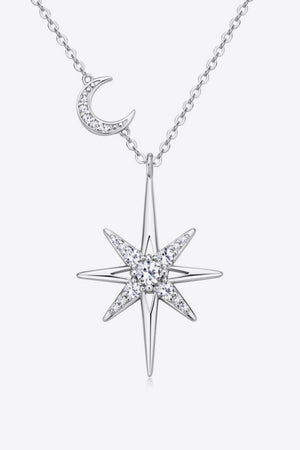 Silver celestial starburst pendant necklace with crescent moon charm, adorned with clear crystals.