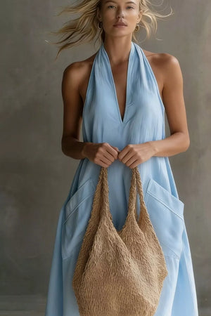 Light blue halter midi dress with pockets and a deep V-neckline.