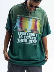 Men's green acid wash graphic t-shirt with colorful figures and text print.