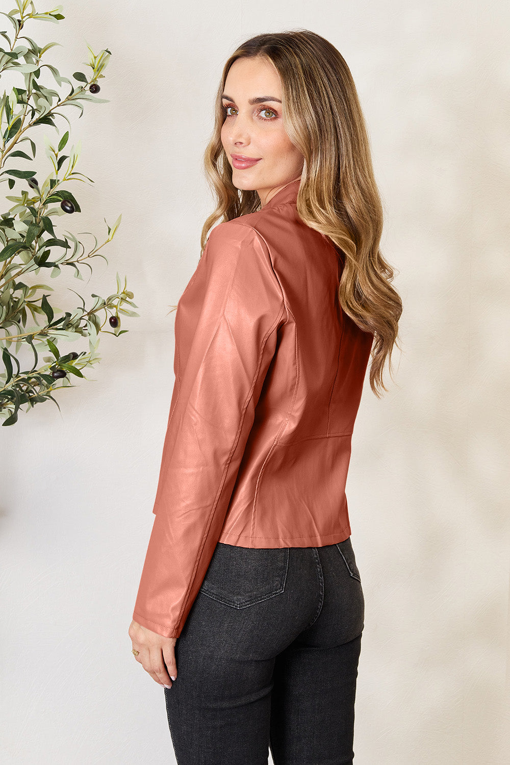 Biker jacket in Burnt Coral faux leather with a stand-up collar and fitted cut.