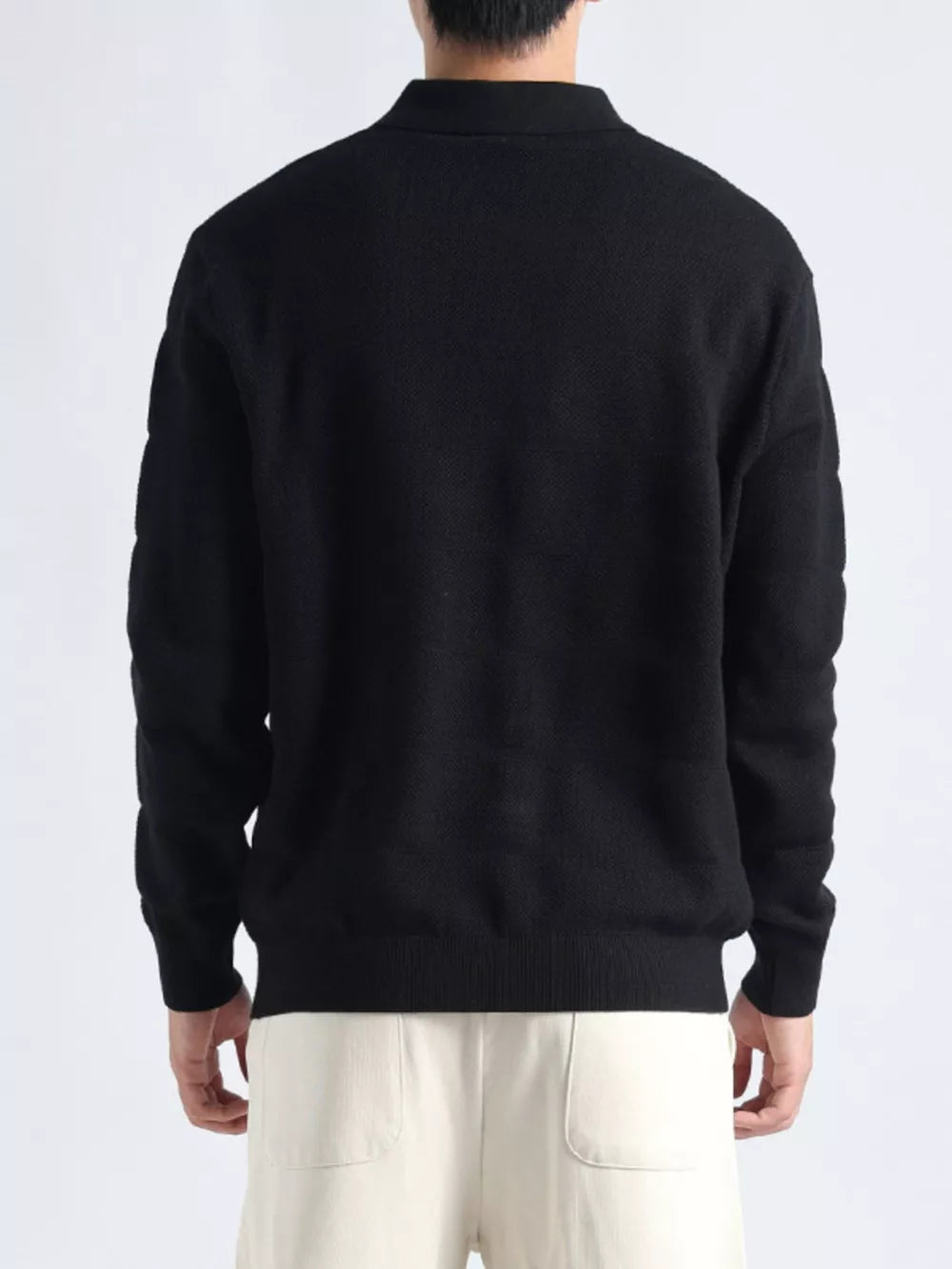 Men's black knit polo top with textured fabric and button accents.