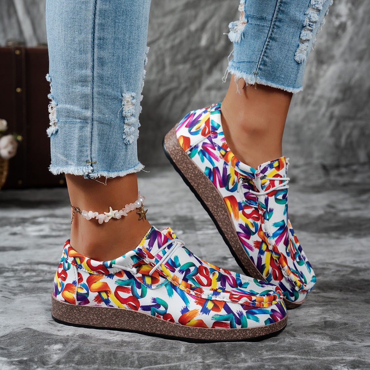 Printed casual slip-on loafers with abstract brushstroke pattern in multiple colors.