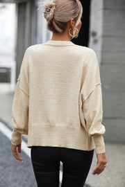 Cream textured bouclé button-down cardigan with crewneck and long sleeves.