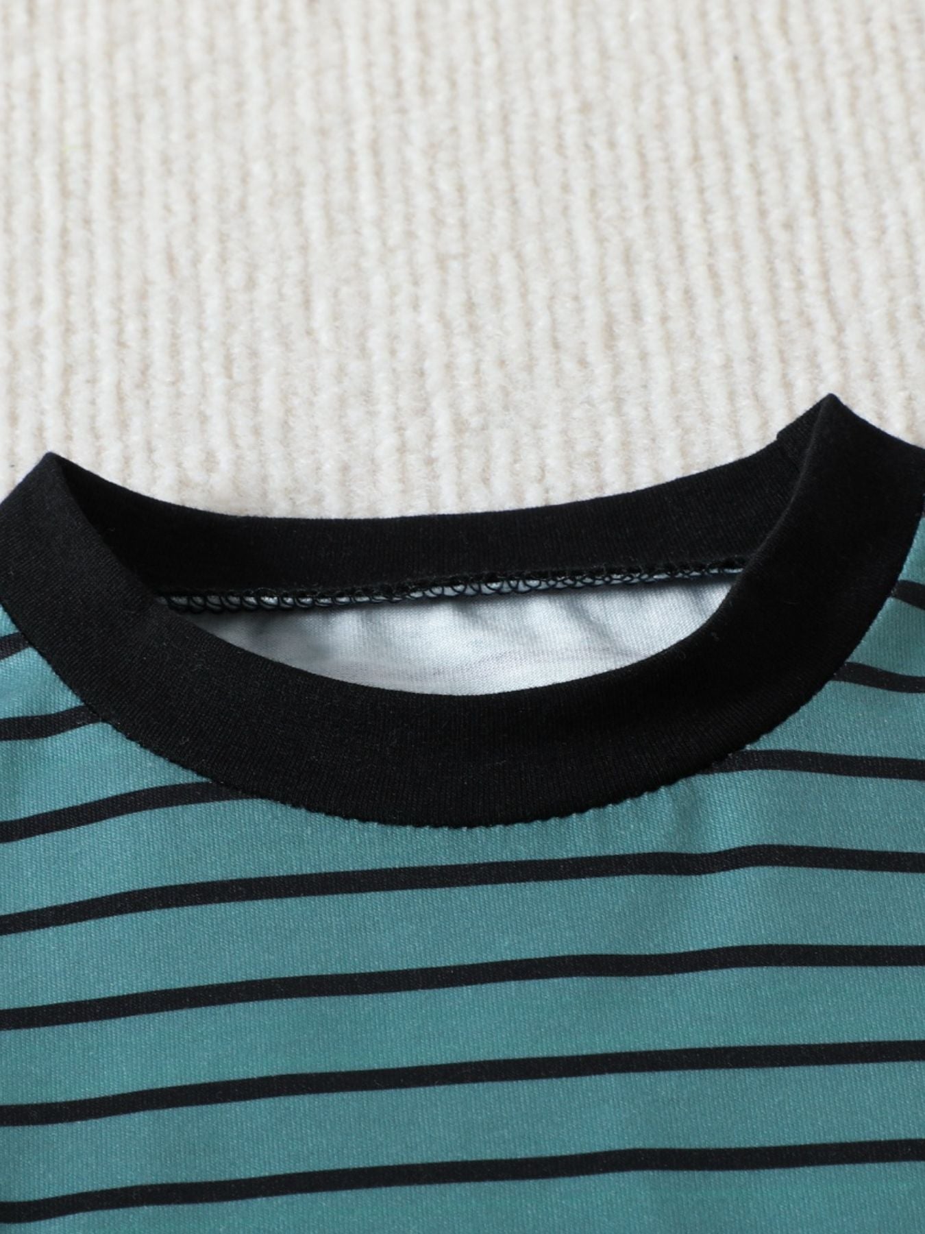 Striped baby t-shirt with black trim and crew neck, made of cotton.