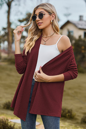 Burgundy textured open-front drape cardigan with long sleeves, styled casually.