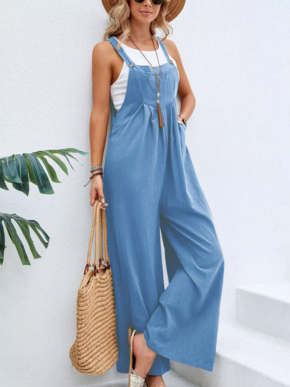 Light blue wide-leg romper with adjustable straps, pockets, and button details.