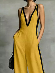 Yellow wide-leg jumpsuit with deep V-neck and black contrast trim.