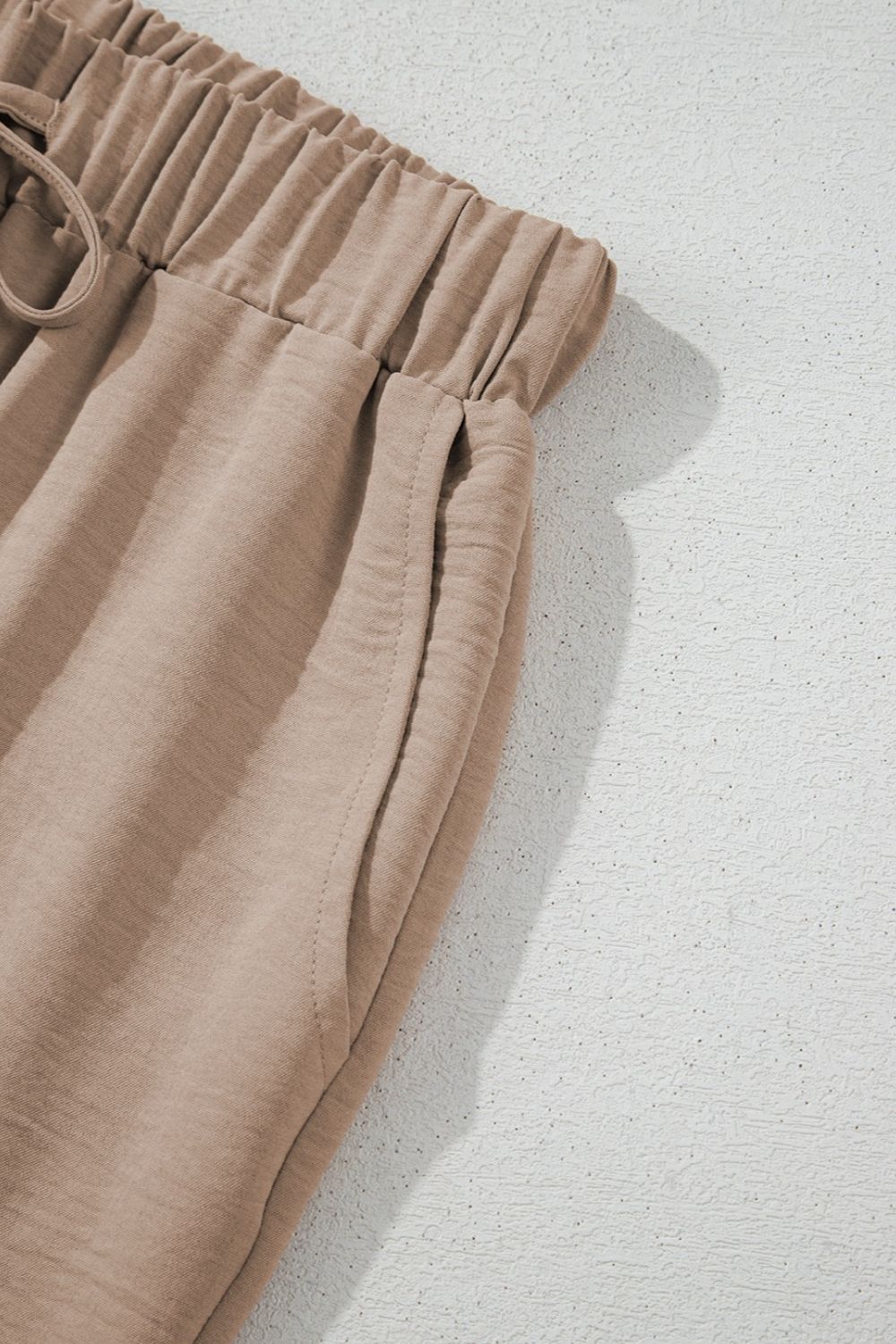 Camel drawstring palazzo pants with elastic waistband and side pockets.