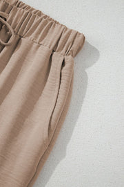 Camel drawstring palazzo pants with elastic waistband and side pockets.