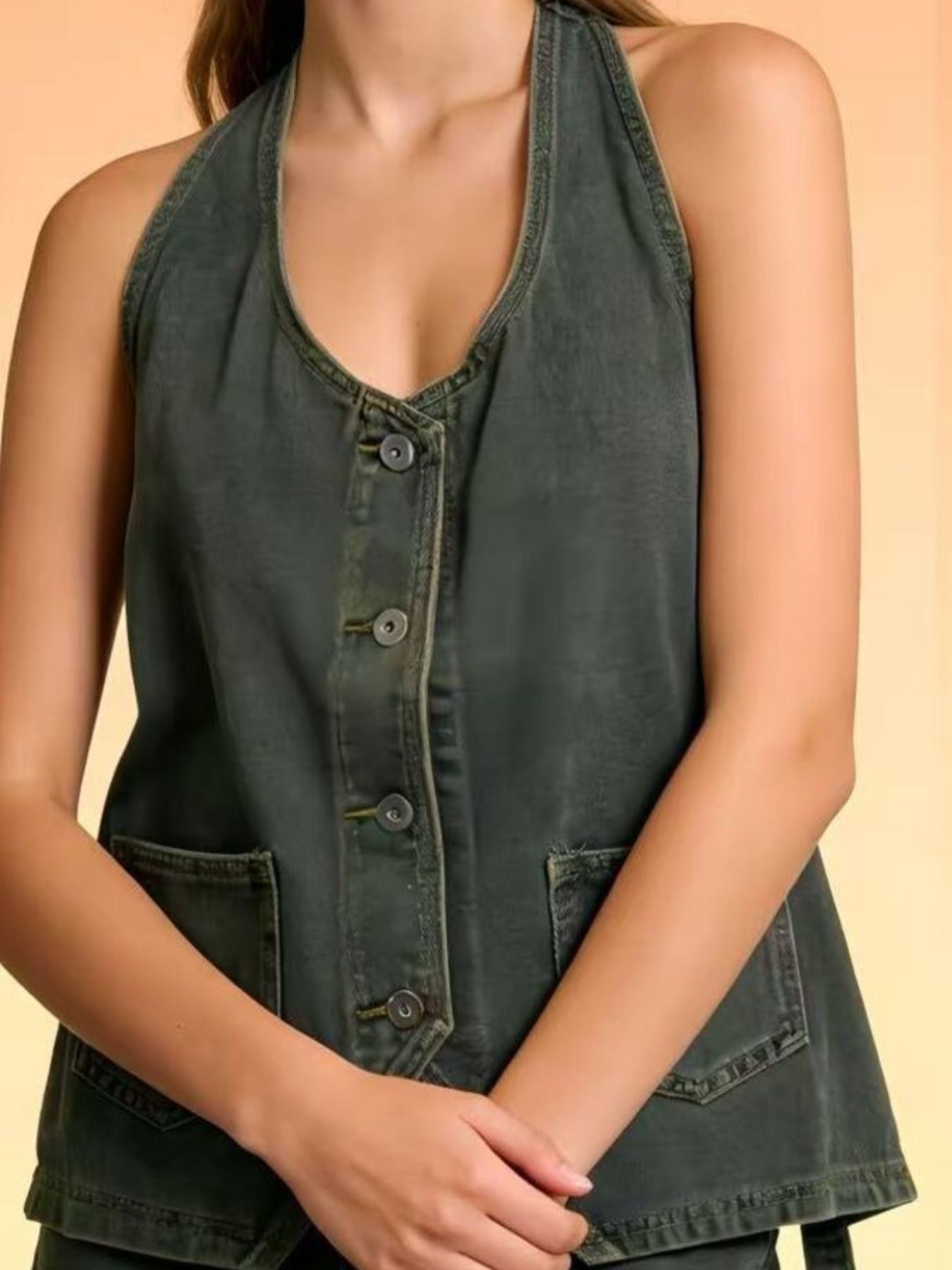 Button-down denim halter vest in gray with two front pockets and a V-neck.