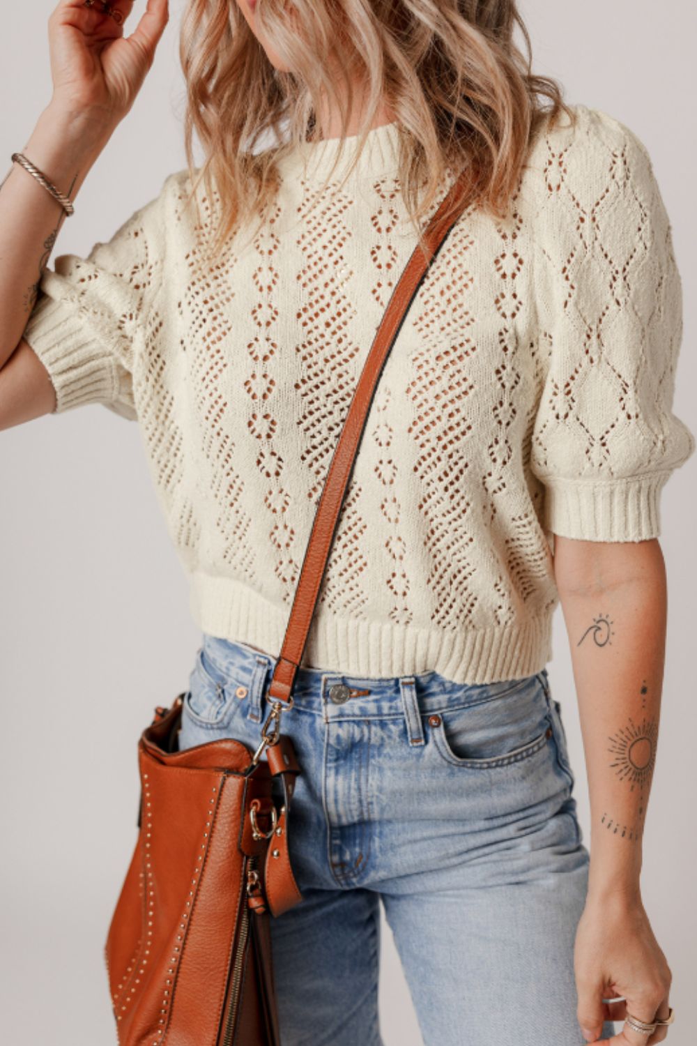 Cream lace-effect knit top with puff sleeves and diamond pattern detail.