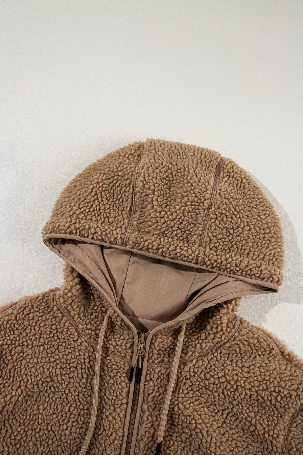 Brown sherpa hooded jacket with contrast lining and drawstring hood.