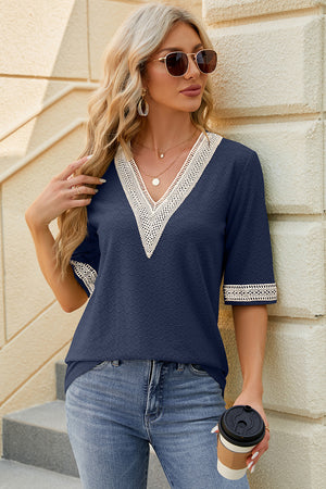 Dark blue textured V-neck top with white lace trim on neckline and sleeves.