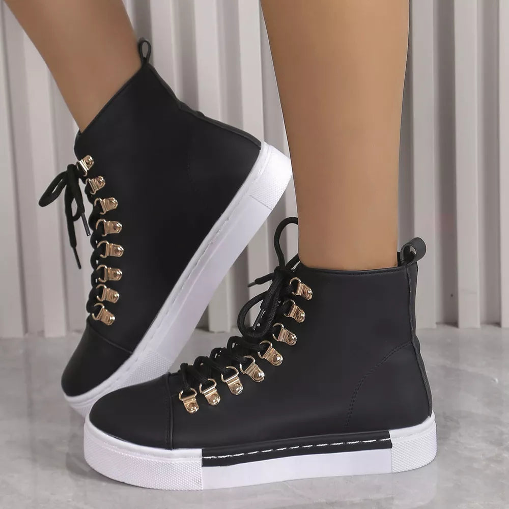 Black lace-up platform sneakers with gold D-ring eyelets and white soles.