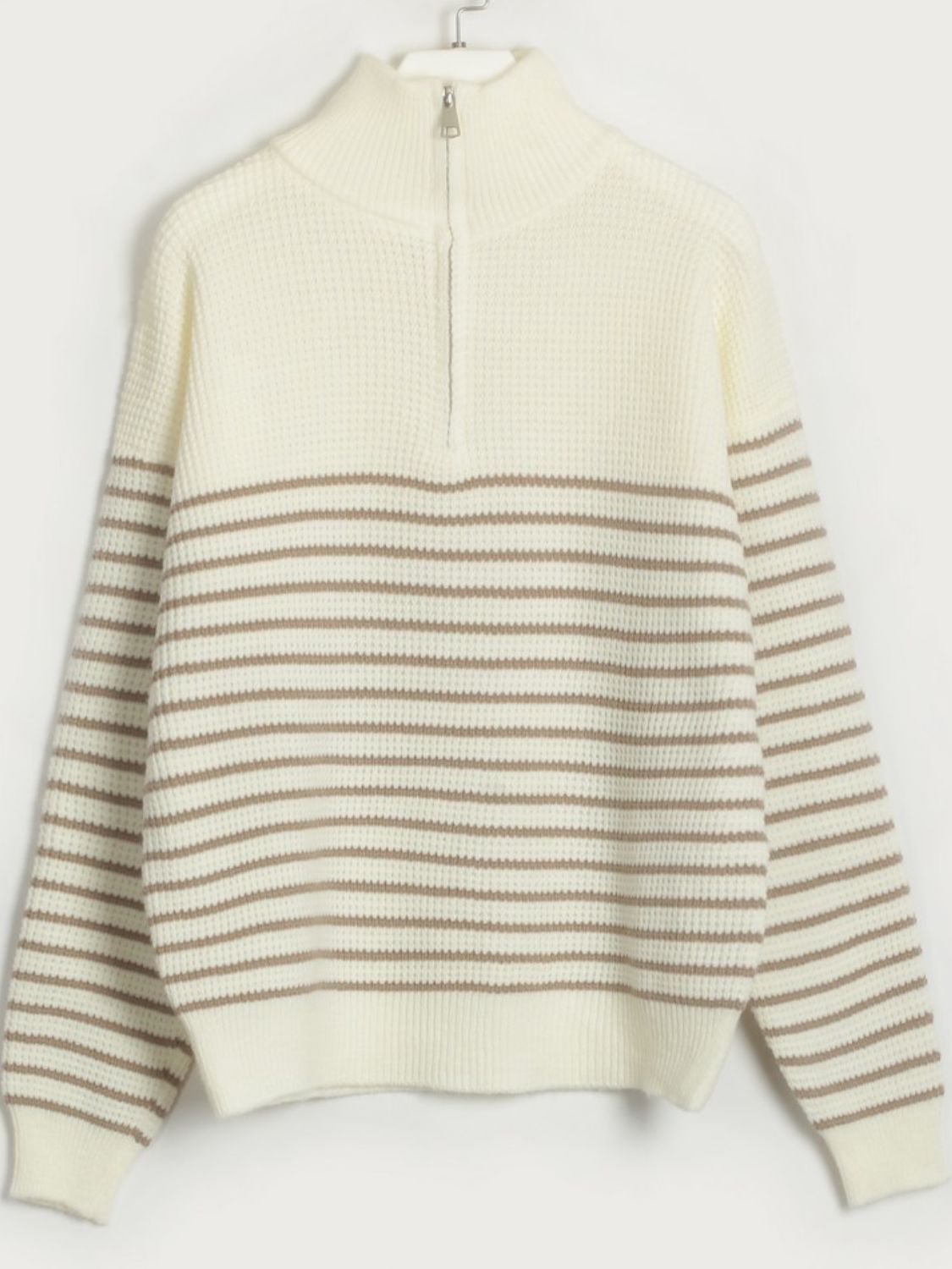 Cream ribbed knit sweater with horizontal caramel stripes and half-zip neckline.