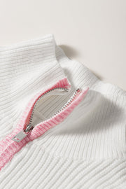 White ribbed quarter-zip pullover with pink trim detail on zipper.